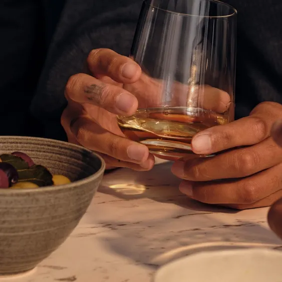 holding glass of Ardray in hand