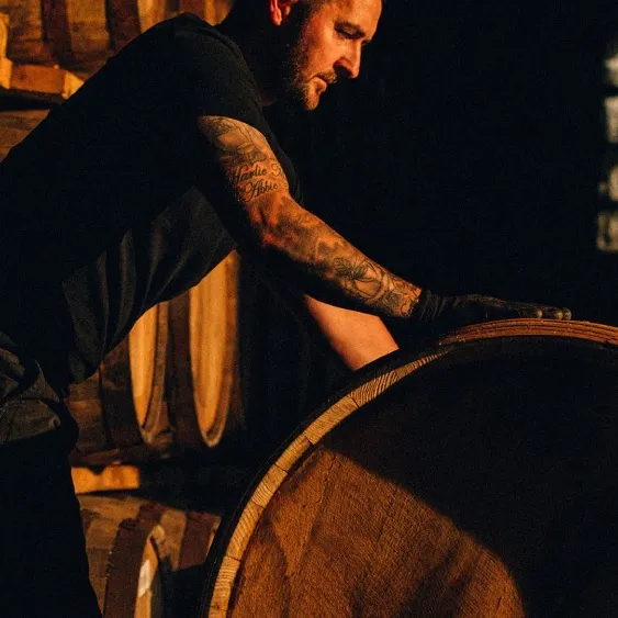 Ardray whisky man rolling barrel in distillery