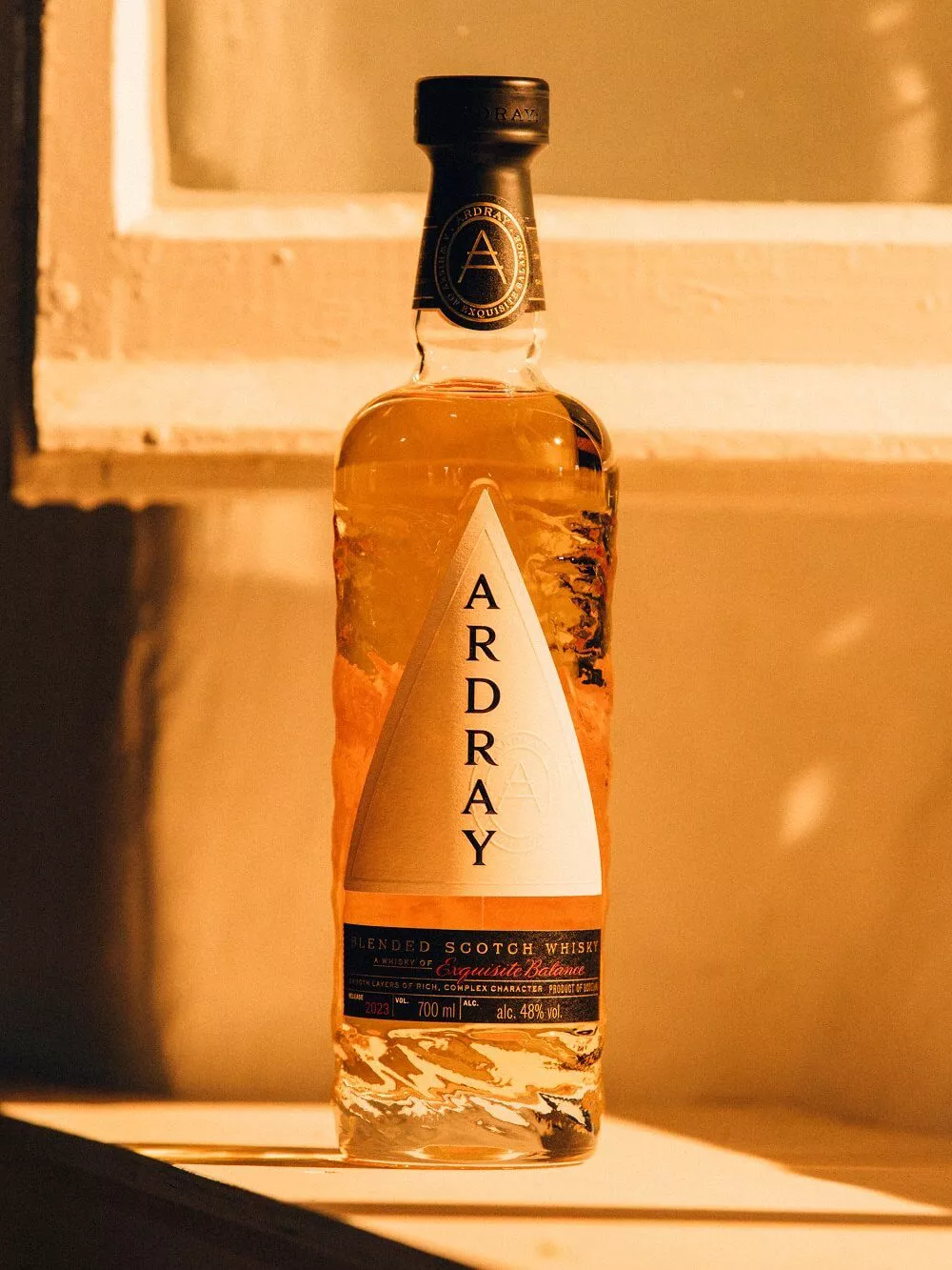 A bottle of Ardray blended Scotch whisky in warm light
